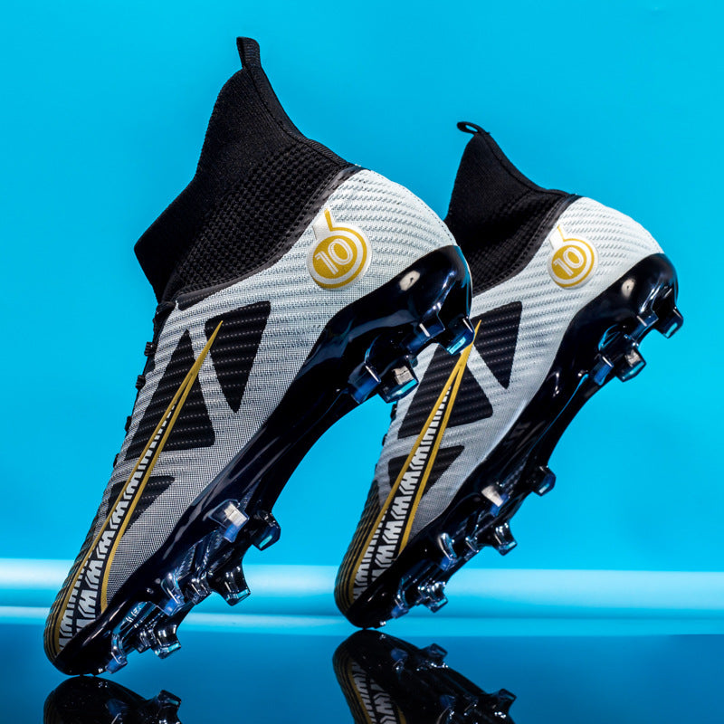 Schwarze und weiße Fußballschuhe mit goldenen Akzenten vor blauem Hintergrund, modernes Design, Stollenschuhe, Sportausrüstung, Fußballschuhe.
