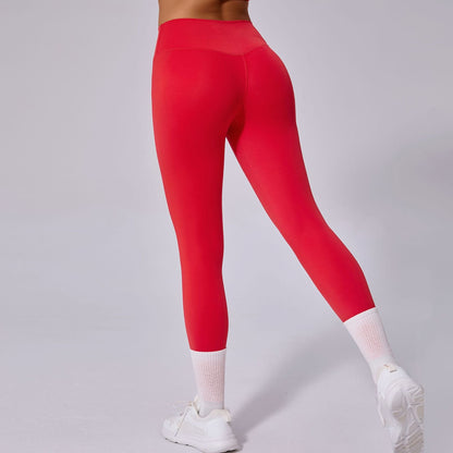 Frau in roten Leggings und weißen Sneakers, Rückansicht. Sportbekleidung, Fitnessmode, bequeme Leggings für Damen, trendige Sportoutfits.