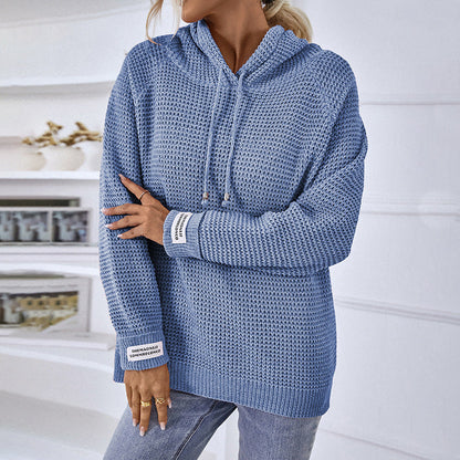 Frau in blauem Strickpullover mit Kapuze, lässiger Stil, modisch, gemütlich, ideal für Herbst und Winter, kombiniert mit Jeans.