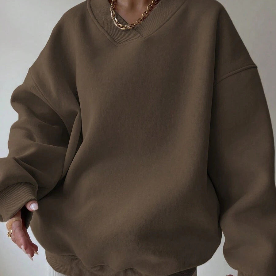 Brauner Oversize-Pullover, lässiger Stil, V-Ausschnitt, modisches Design, Damenmode, Herbst-Winter-Trend, gemütlicher Look, goldene Halskette.