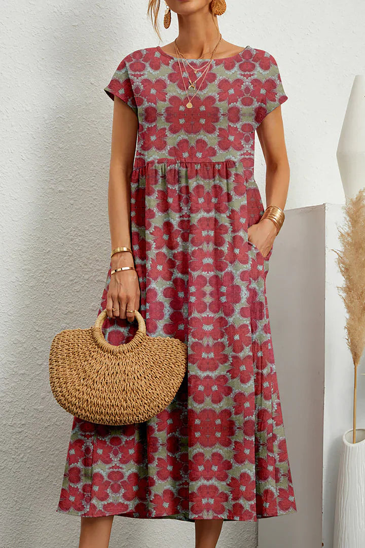Frau in rotem, geblümtem Sommerkleid mit kurzen Ärmeln, hält eine runde Strohtasche. Perfekt für lässige Sommermode und Boho-Stil.