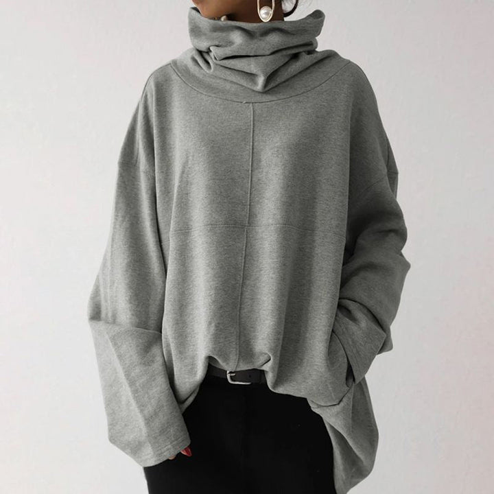 Grauer Oversize-Pullover mit Rollkragen, lässig geschnitten, aus weichem Material. Perfekt für Herbstmode und gemütliche Outfits.
