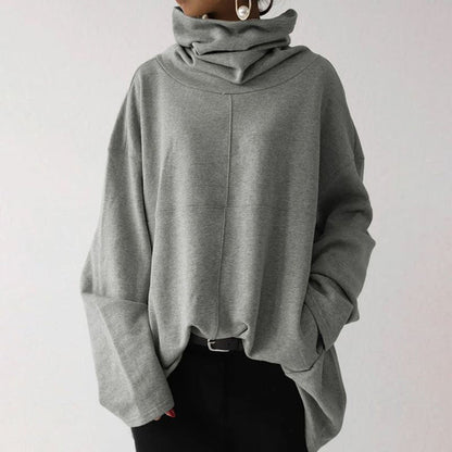 Grauer Oversize-Pullover mit Rollkragen, lässig geschnitten, aus weichem Material. Perfekt für Herbstmode und gemütliche Outfits.
