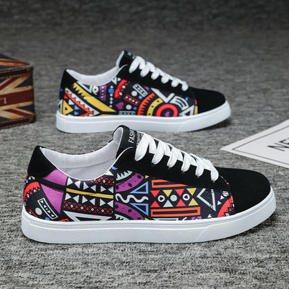 Bunte Sneaker mit geometrischem Muster, schwarzer Spitze und weißer Sohle auf grauem Hintergrund. Modische Freizeitschuhe für Herren.