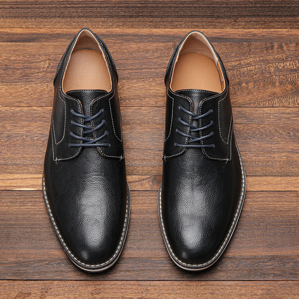 Schwarze Herren-Lederschnürschuhe auf Holzboden, elegante Business-Schuhe, klassische Mode, hochwertige Verarbeitung, ideal für formelle Anlässe.