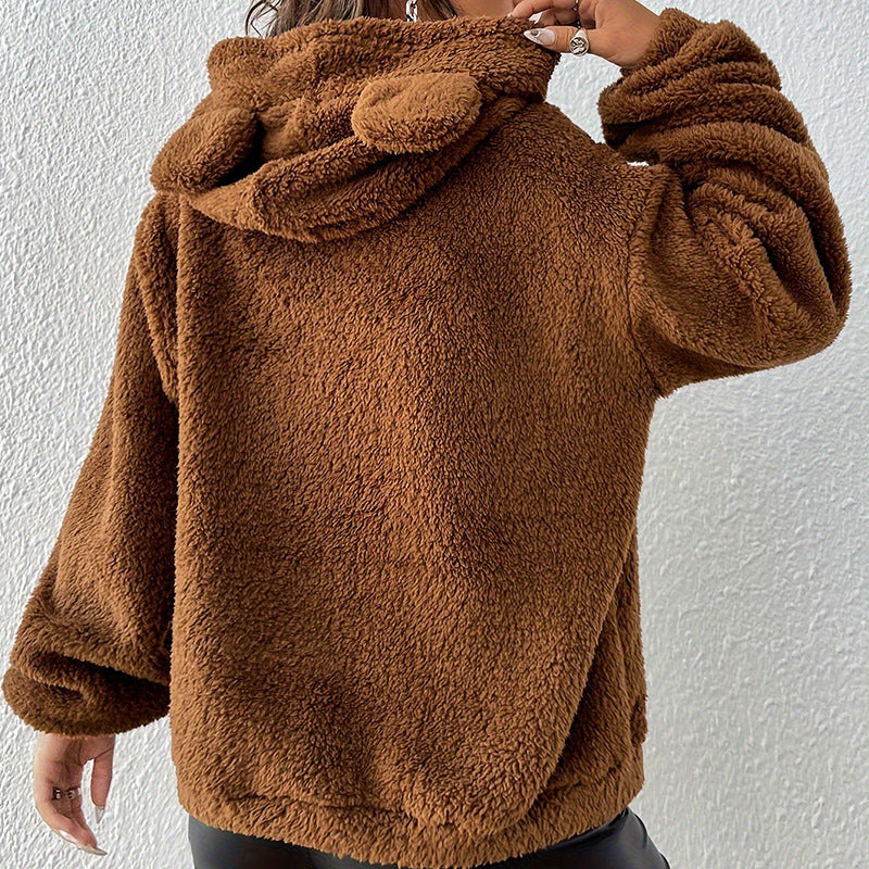 Frau in brauner Teddyfelljacke mit Kapuze und Bärenohren, Rückansicht. Modetrend, kuscheliger Wintermantel, Damenbekleidung, warm und stilvoll.