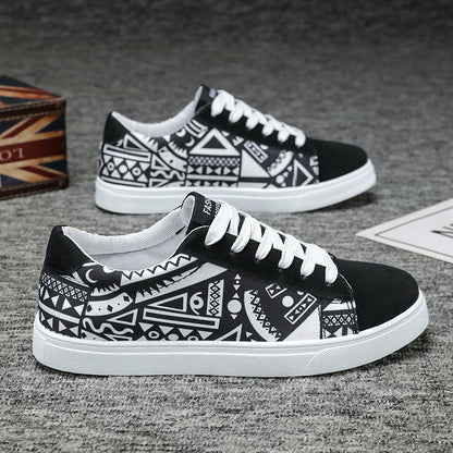 Schwarze und weiße Sneaker mit geometrischem Muster, flache Sohle und Schnürsenkeln auf grauem Hintergrund. Modische Freizeitschuhe für Herren.