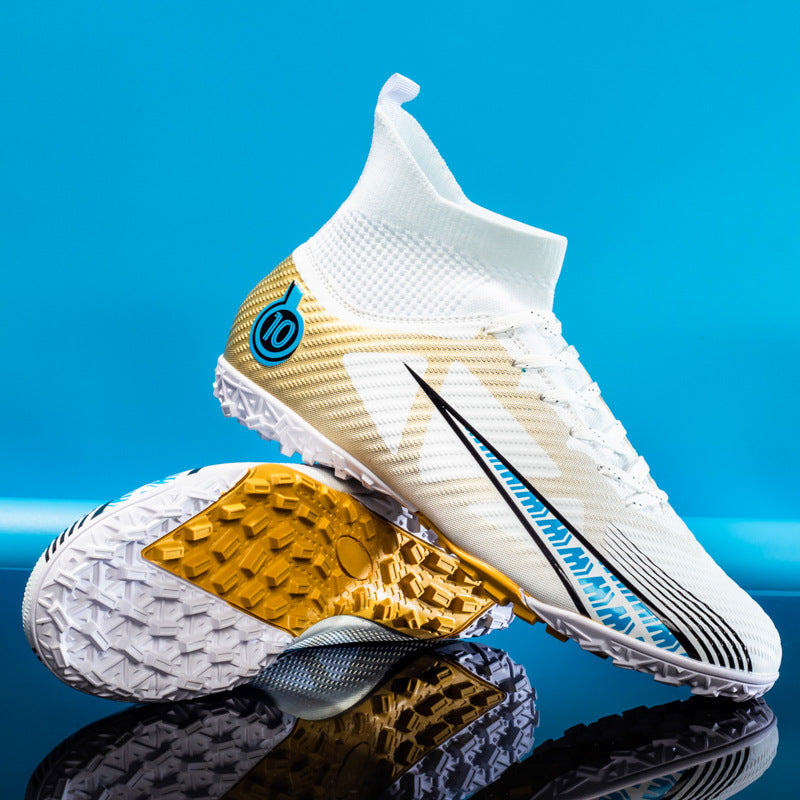 Weiße Fußballschuhe mit goldenen und blauen Akzenten, Stollenprofil für Kunstrasen, modernes Design, auf blauem Hintergrund.
