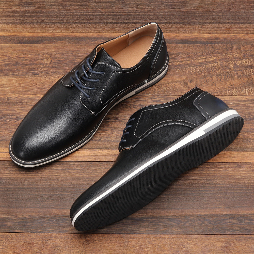 Schwarze Herrenschuhe aus Leder mit Schnürung auf Holzboden. Elegante Business-Schuhe, rutschfeste Sohle, ideal für formelle Anlässe.
