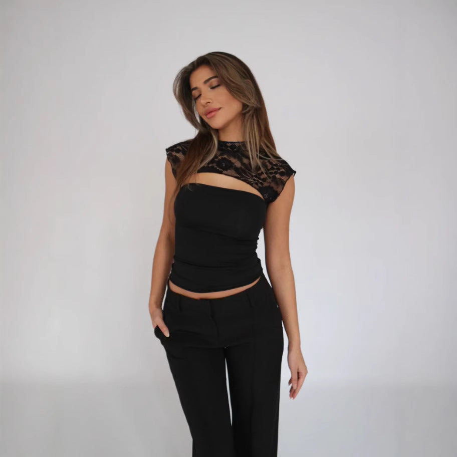 Eine Frau in eleganter schwarzer Kleidung mit Spitzenoberteil und Hose vor weißem Hintergrund. Mode, Damenbekleidung, stilvolles Outfit.
