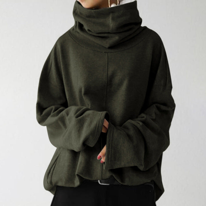 Dunkelgrüner Oversize-Pullover mit hohem Kragen und langen Ärmeln, getragen von einer Person. Modetrend, gemütlicher Look, Herbstmode.