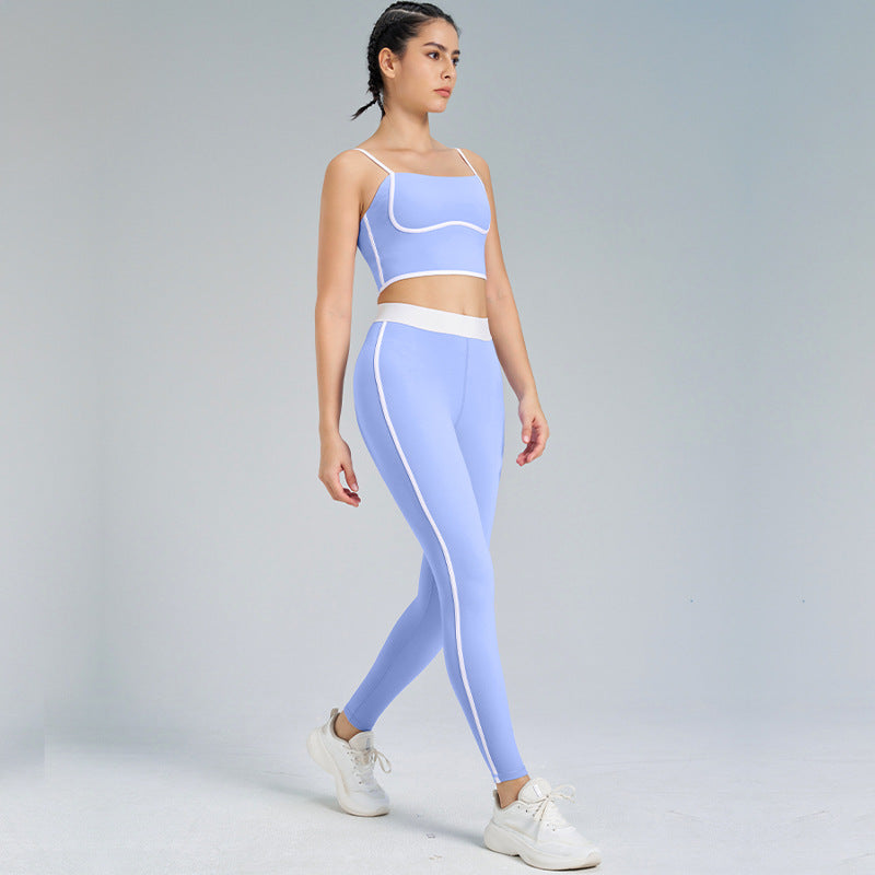 Frau in blauer Sportbekleidung, bestehend aus Leggings und Top, beim Gehen. Fitnessmode, Sportoutfit, aktive Kleidung, Studiohintergrund.