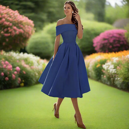 Frau im eleganten blauen Abendkleid im Garten, umgeben von blühenden Blumen. Perfektes Outfit für Sommerhochzeiten oder formelle Anlässe.