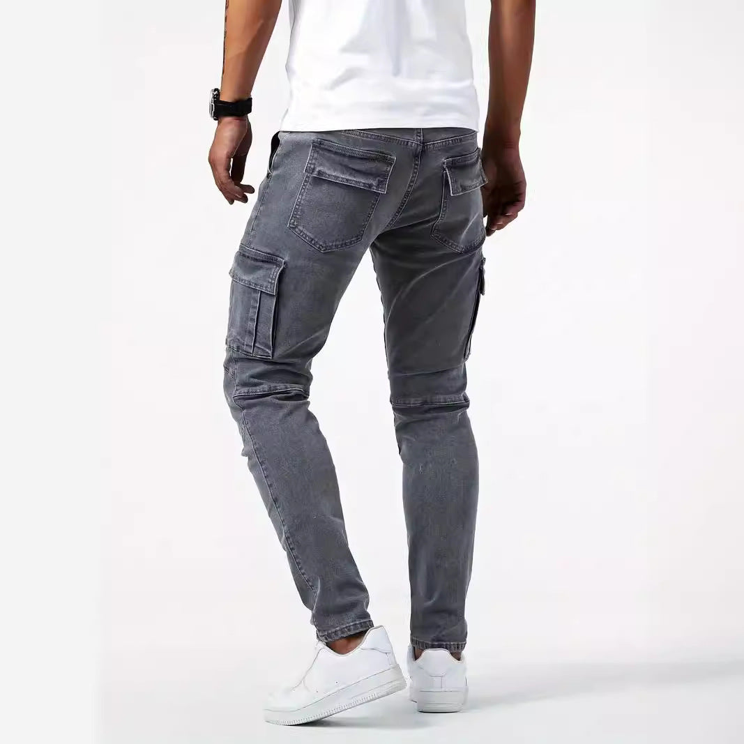 Mann in grauer Cargohose, Rückansicht, trägt weißes T-Shirt und weiße Sneaker. Modische Herrenbekleidung, lässiger Stil, urbaner Look.
