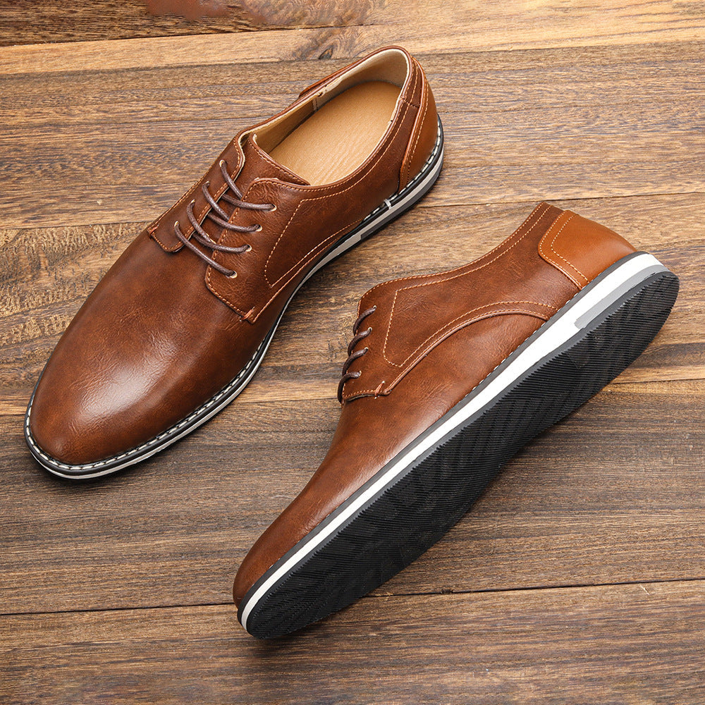 Braune Herren-Lederschnürschuhe auf Holzboden, elegante Business-Schuhe mit weißer Sohle, modische Herrenschuhe für Büro und Freizeit.