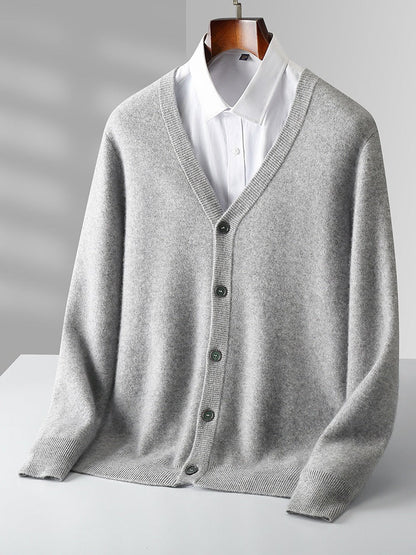 Grauer Herren-Cardigan aus Kaschmir mit V-Ausschnitt, Knopfleiste und weißem Hemd. Elegante, warme Strickmode für Herbst und Winter.