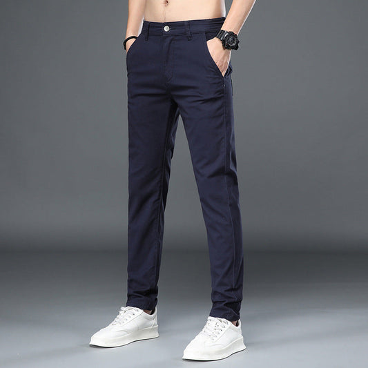 Dunkelblaue Herren-Chinohose, modern geschnitten, mit weißem Knopf, kombiniert mit weißen Sneakers. Ideal für Freizeit und Büro.