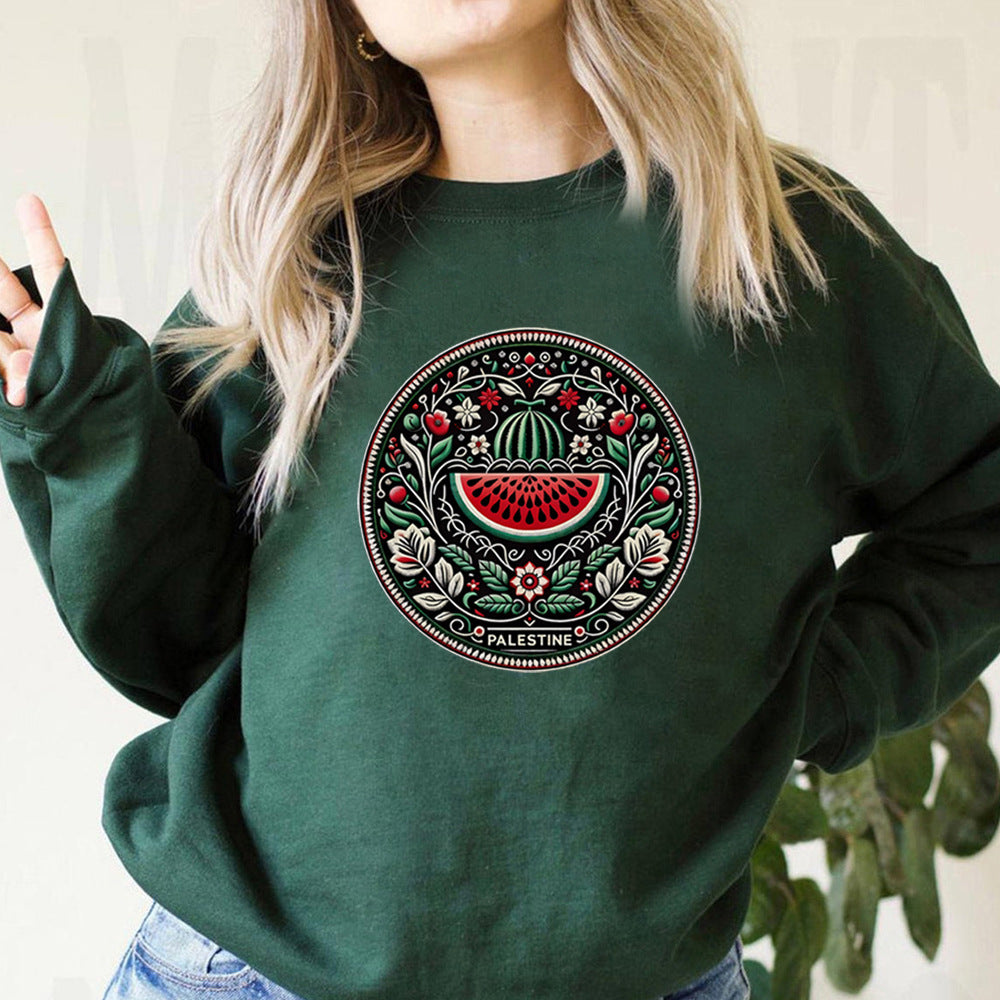Frau trägt grünen Pullover mit palästinensischem Stickmuster, Wassermelonen-Design. Modetrend, Ethno-Mode, nachhaltige Kleidung.