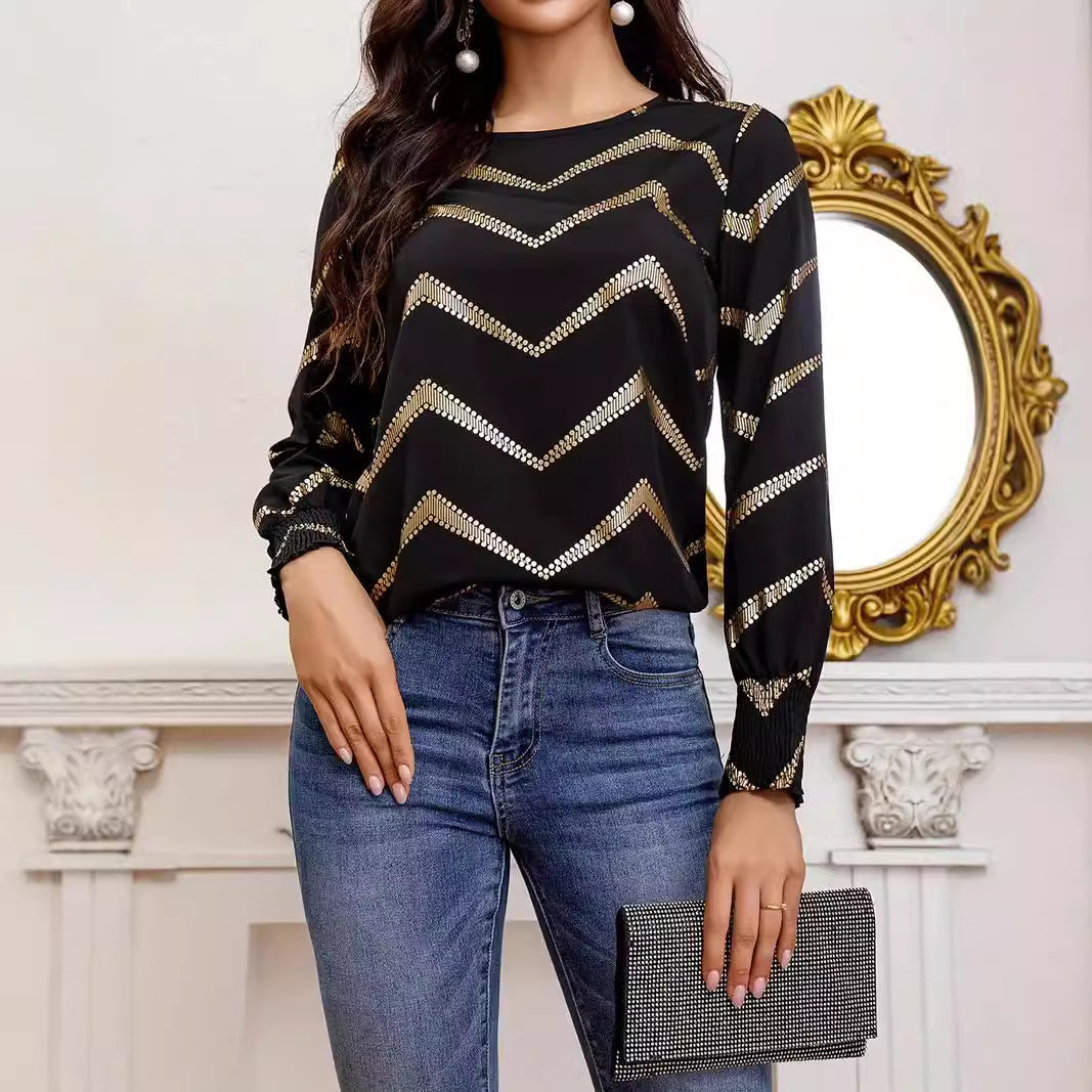 Frau in schwarzer Bluse mit goldenen Zickzack-Mustern, blauen Jeans, hält glitzernde Clutch. Elegante Mode, stilvolles Outfit, modische Kleidung.