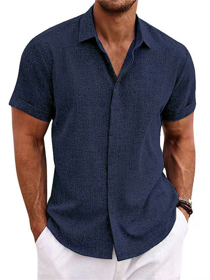 Mann in dunkelblauem Kurzarmhemd und weißen Hosen. Sommermode, Herrenbekleidung, lässiger Stil, elegantes Design.