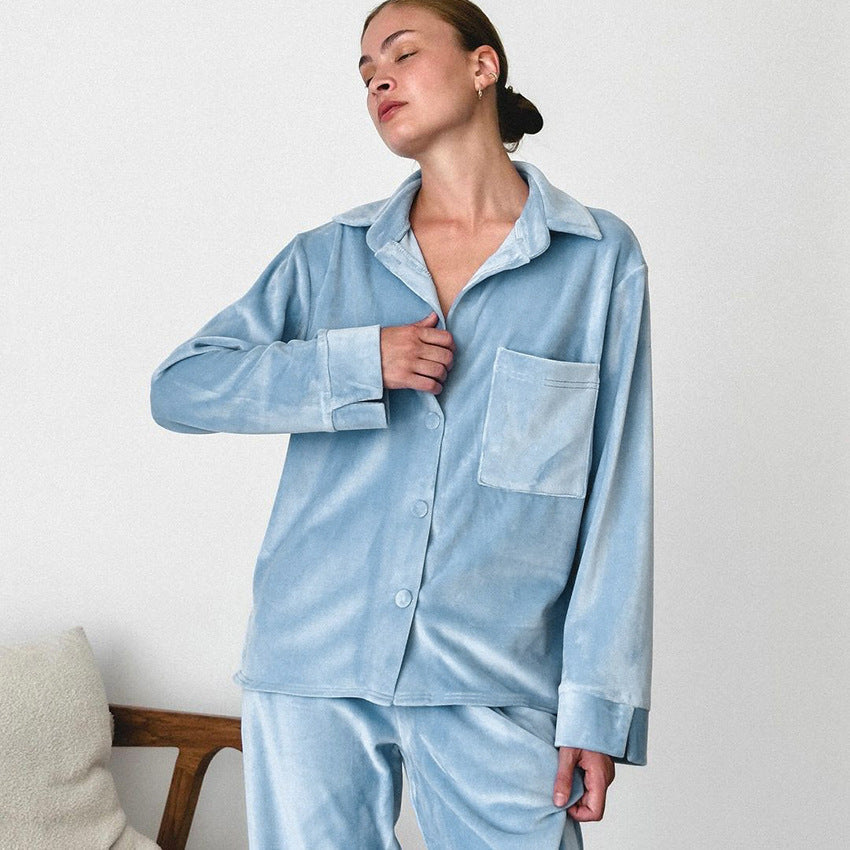 Frau in hellblauem Samt-Pyjama, entspannt posierend. Bequeme Nachtwäsche, modischer Schlafanzug, weicher Stoff, elegantes Design.