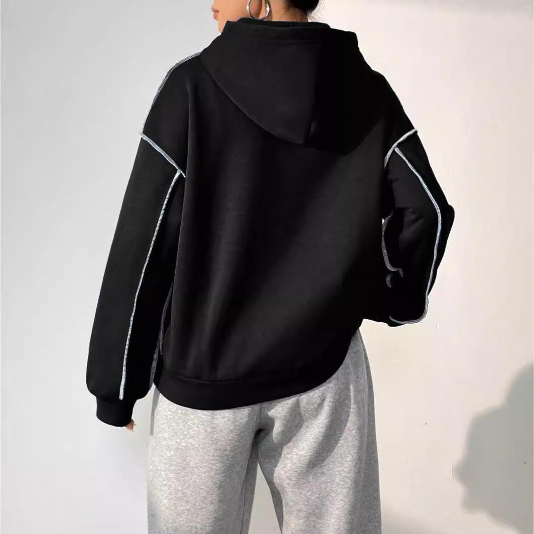 Person in schwarzem Hoodie und grauer Jogginghose von hinten. Bequeme Freizeitmode, sportlicher Look, lässiger Stil.