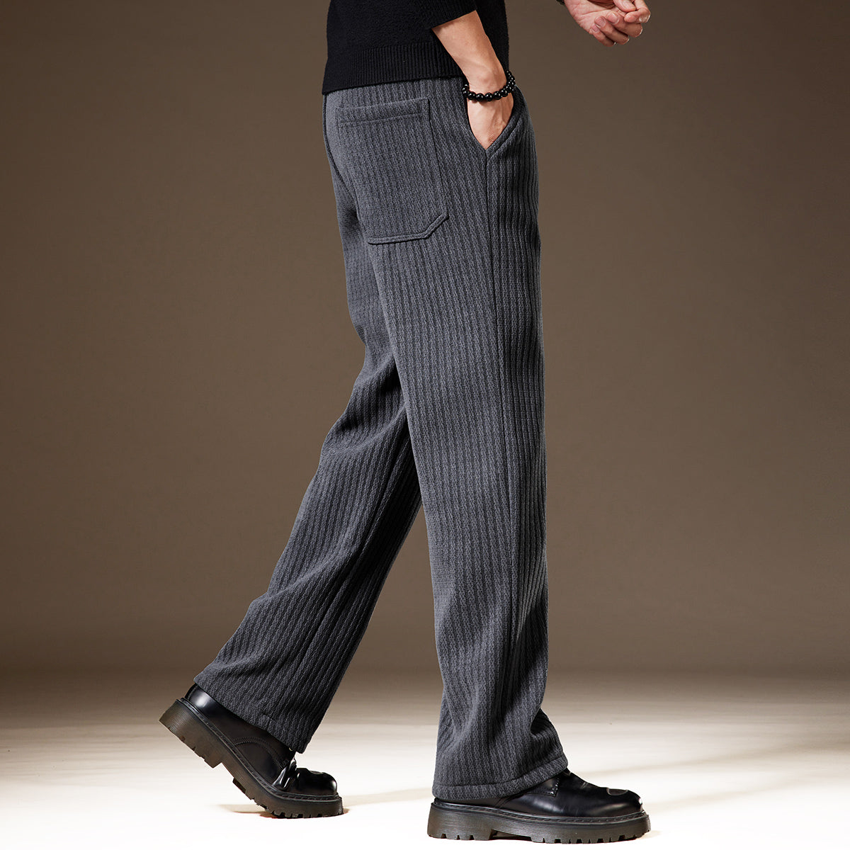 Graue, gerippte Herren-Hose aus Wolle, seitlich fotografiert. Modischer, bequemer Stil, ideal für Herbst- und Wintermode.