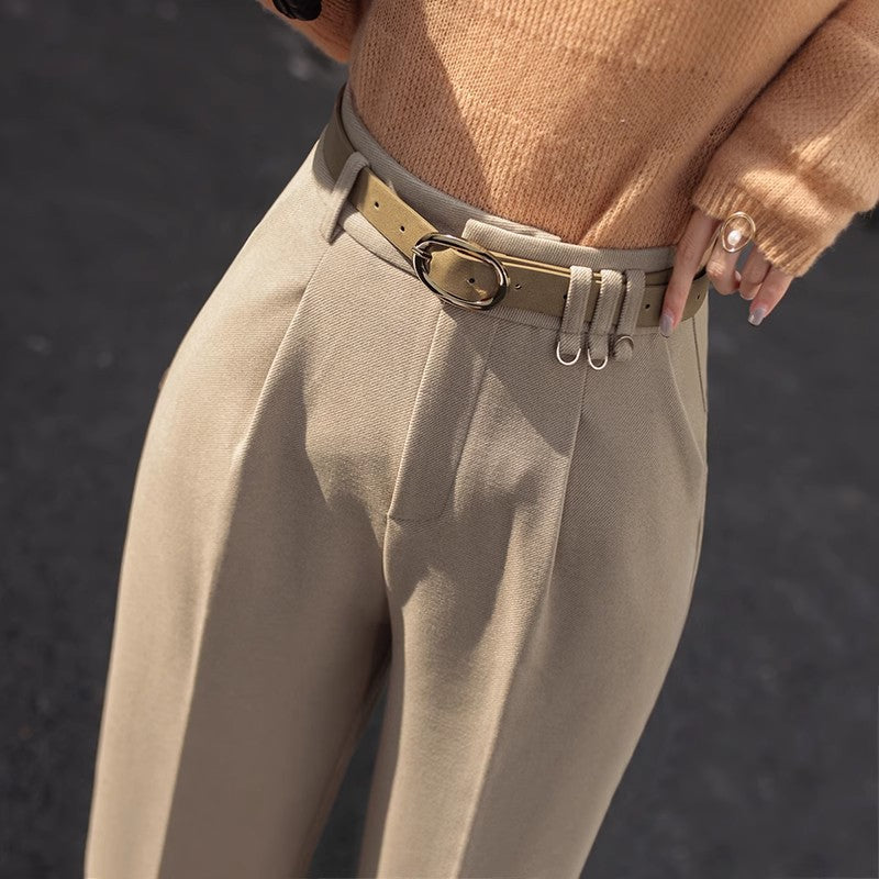 Braune Hose mit hohem Bund und Gürtel, kombiniert mit einem beige Pullover. Modetrend Herbst, elegante Damenbekleidung, stilvolle Outfits.
