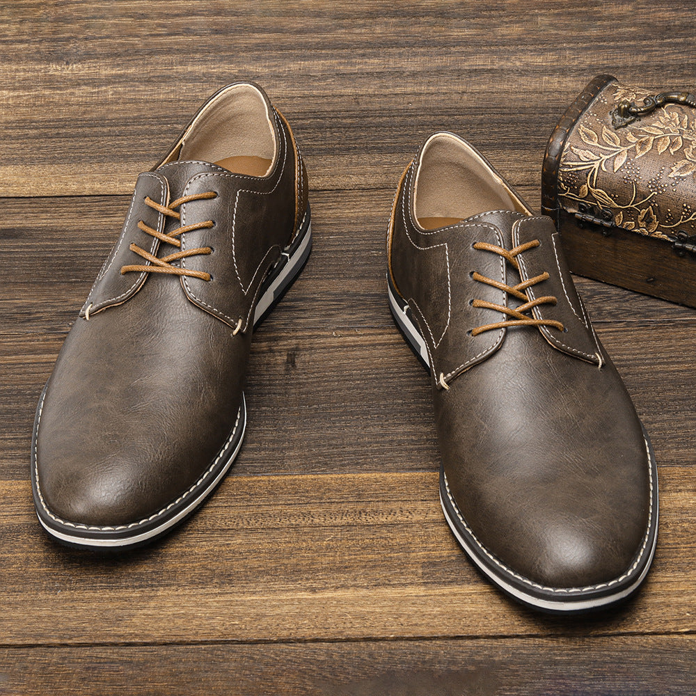 Braune Herren-Lederschnürschuhe auf Holzboden, elegantes Design, klassische Mode, hochwertige Materialien, ideal für Business und Freizeit.