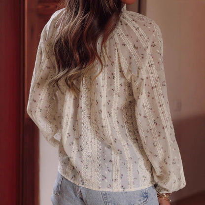 Rückansicht einer Frau in einer geblümten, durchsichtigen Bluse und Jeans, langes gewelltes Haar, modisches Outfit, lässiger Stil.