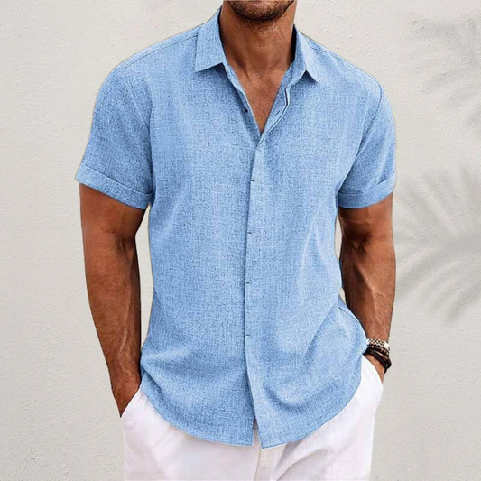 Herrenhemd aus Leinen in Hellblau, kurzärmelig, lässiger Stil, ideal für Sommermode. Perfekt kombinierbar mit weißen Hosen für einen eleganten Look.