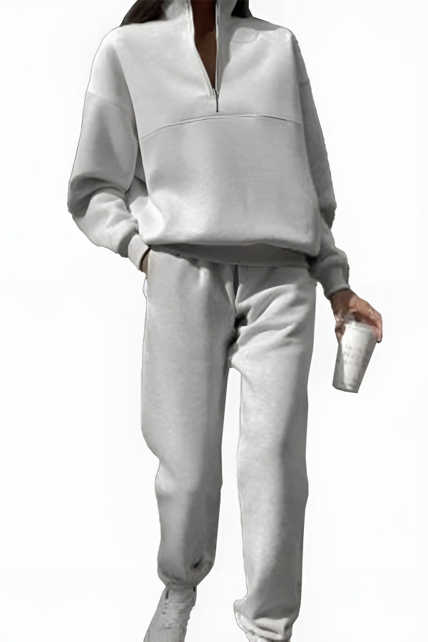 Damen Jogginganzug in Grau, bestehend aus Sweatshirt mit Reißverschluss und Jogginghose. Bequemes Freizeitoutfit, ideal für Sport und Alltag.