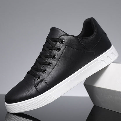 Schwarzer Sneaker aus Leder mit weißer Sohle, seitlich aufgestellt. Modischer Herrenschuh, ideal für Freizeit und Alltag.
