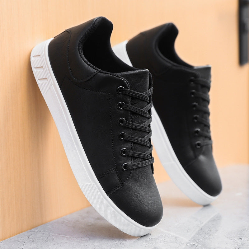 Schwarze Sneaker mit weißer Sohle, seitlich an Holzwand lehnend. Modische Herrenschuhe, ideal für Freizeit und Sport.