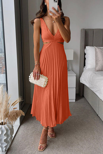 Frau in elegantem, orangefarbenem Abendkleid mit tiefem Ausschnitt, hält eine Perlen-Clutch, steht in modernem Schlafzimmer mit großem Fenster.