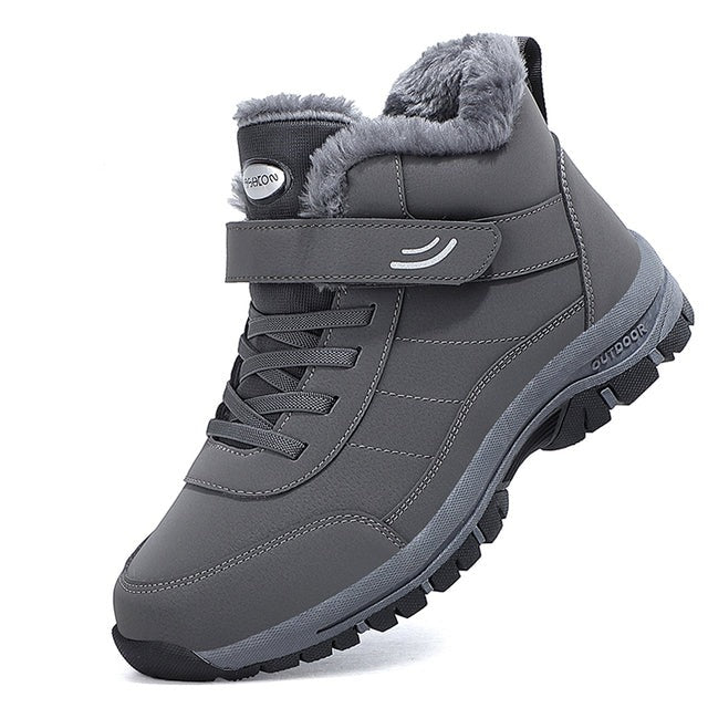 Grauer Winterstiefel mit Kunstfellfutter, rutschfester Sohle und Klettverschluss. Ideal für Outdoor-Aktivitäten bei kaltem Wetter.