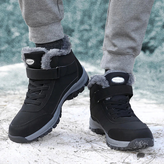 Schwarze Winterstiefel mit grauem Kunstfellfutter, robustem Profil und Klettverschluss, getragen auf schneebedecktem Boden. Ideal für kaltes Wetter.