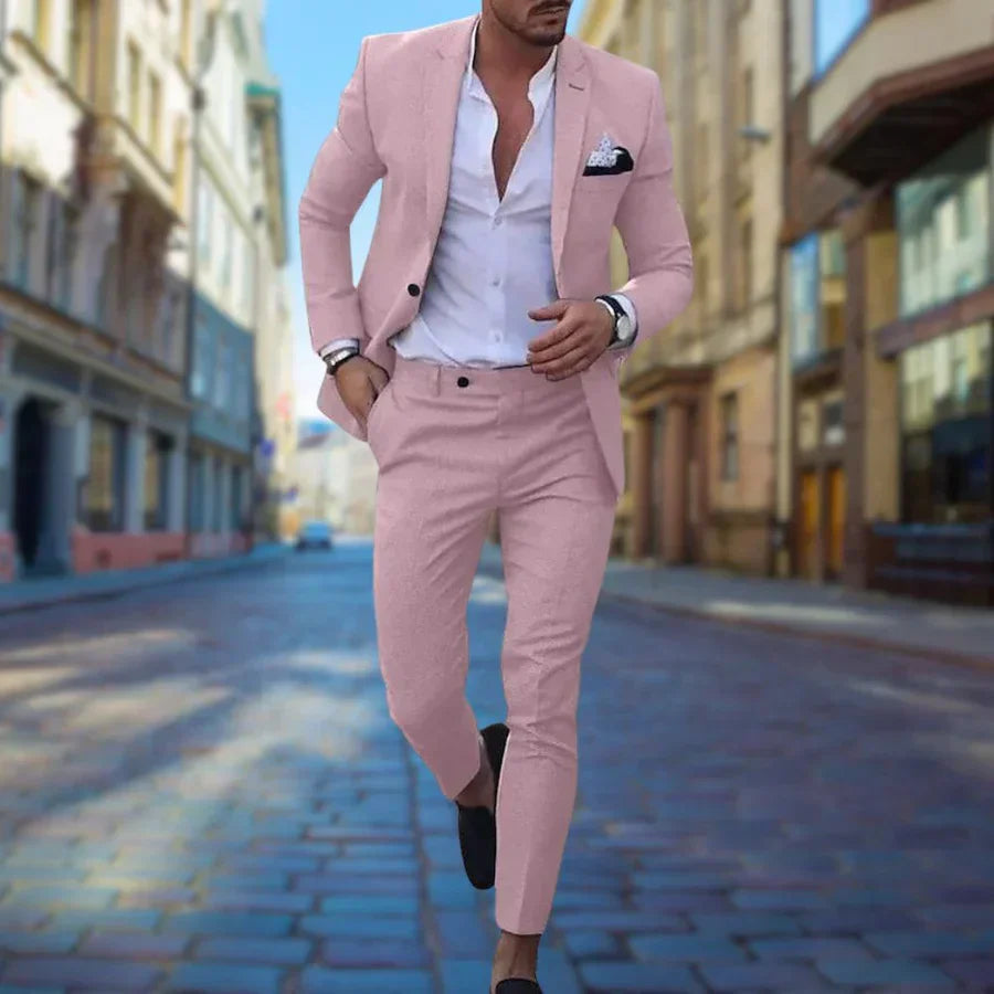 Mann in rosa Anzug und weißem Hemd läuft auf gepflasterter Straße in urbaner Umgebung. Elegante Herrenmode, stilvoller Look, Stadtmode.