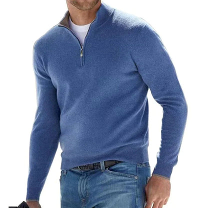 Blauer Herrenpullover mit Reißverschluss, lässig getragen über weißem T-Shirt und Jeans. Modischer Freizeitlook für Männer.