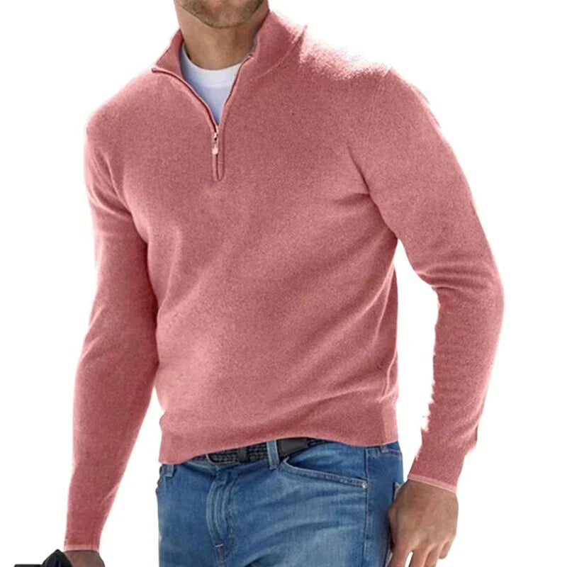 Mann in rosa Pullover mit Reißverschluss, lässig gekleidet in blauer Jeans. Modischer Herrenpullover, ideal für Herbst und Winter.