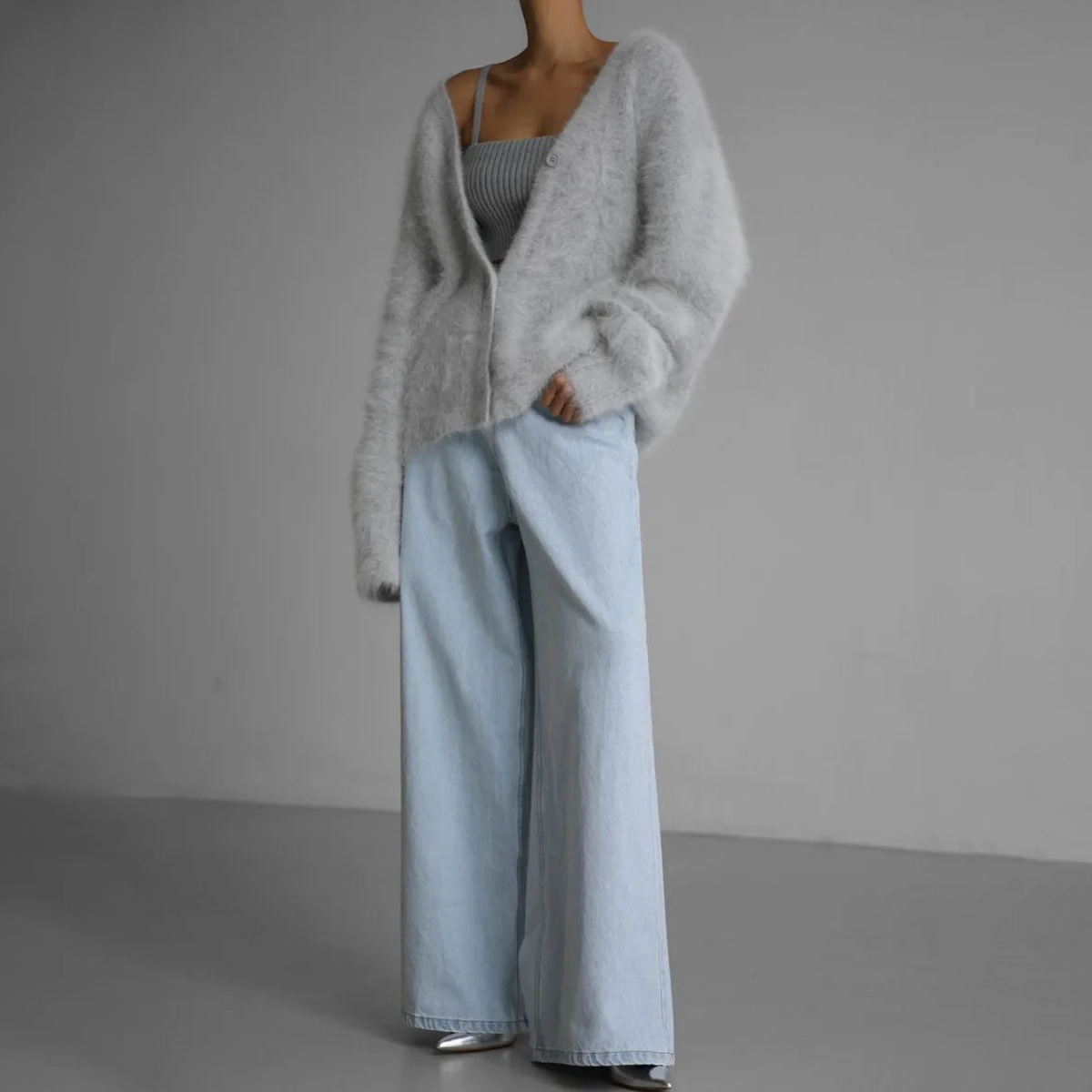 Dame in grauem Strickcardigan und hellblauer Jeans, modisches Outfit, minimalistisch, Herbstmode, gemütlicher Look, stilvolle Damenbekleidung.