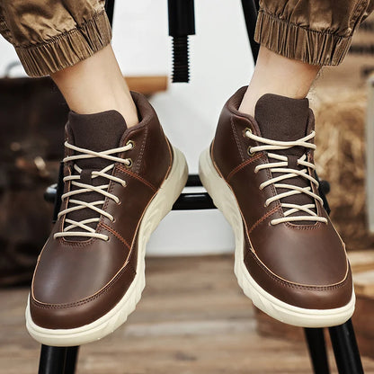 Braune Herren-Sneaker aus Leder mit beiger Sohle und Schnürsenkeln, getragen von einer Person in hochgekrempelten Hosen.