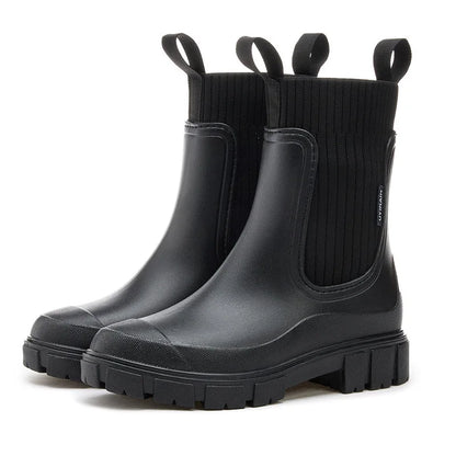 Schwarze Gummistiefel mit dicker Sohle, elastischem Schaft und Zuglaschen. Modische, wasserdichte Stiefel für Damen. Ideal für Regenwetter.