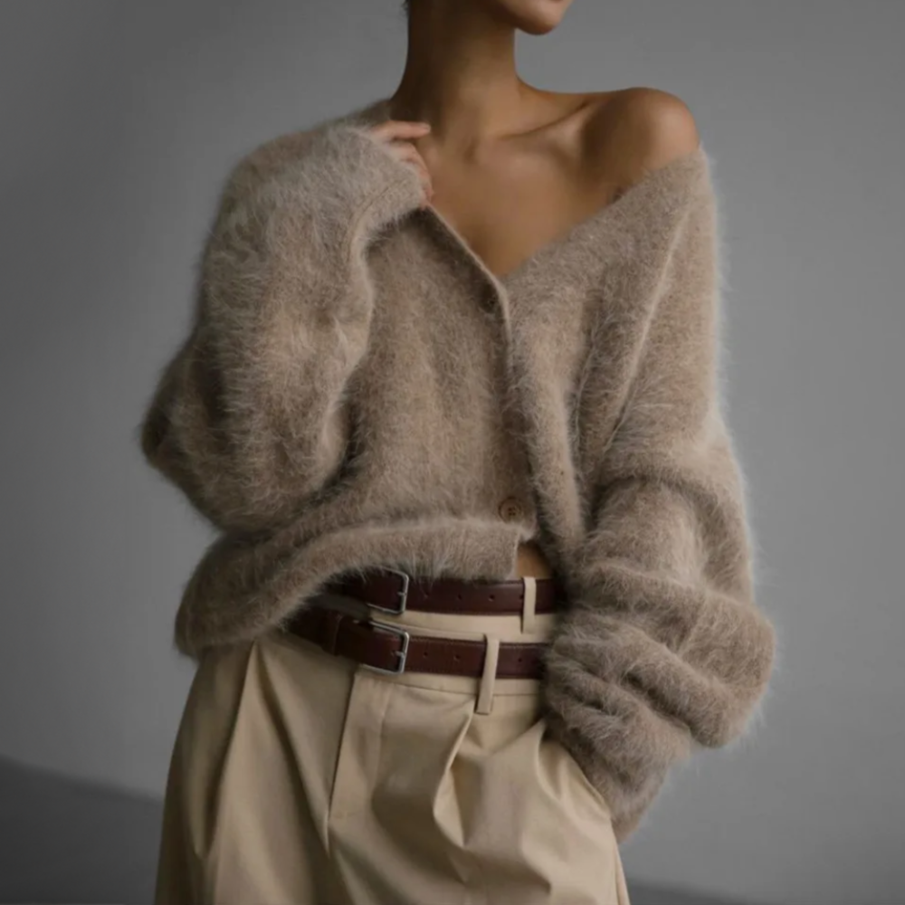 Frau in beigem, flauschigem Strickpullover und beiger Hose mit Gürtel. Modetrend, Herbstmode, gemütlicher Look, eleganter Stil.