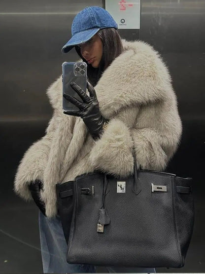 Frau im Aufzug mit Pelzmantel, blauer Kappe und schwarzer Lederhandtasche. Luxuriöse Mode, Selfie, Winteroutfit, Accessoires.