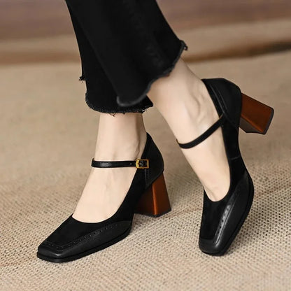 Schwarze Damen-Mary-Jane-Pumps mit Blockabsatz und Schnalle, getragen auf Teppichboden. Elegante, modische Schuhe für Büro und Alltag.