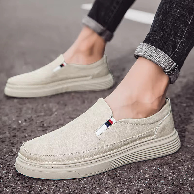 Beige Herren-Sneaker aus Canvas, lässig und modern, mit gestreiftem Logo-Detail, ideal für Freizeit und Alltag, getragen auf Asphalt.