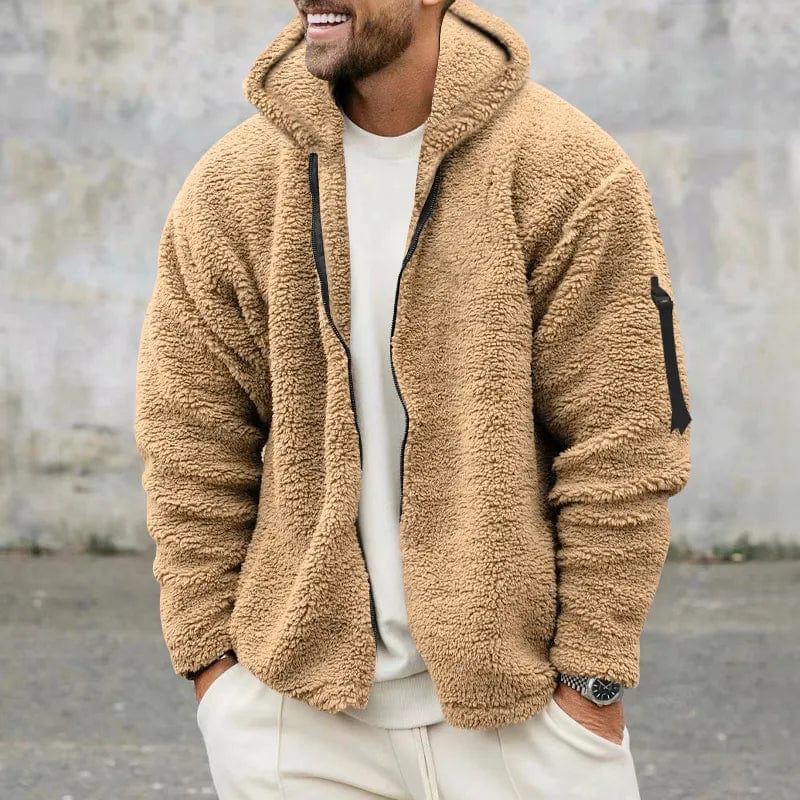 Mann trägt beige Teddyfleece-Jacke mit Kapuze, lässiger Stil, modisch und warm, ideal für Herbst und Winter, vor grauem Hintergrund.