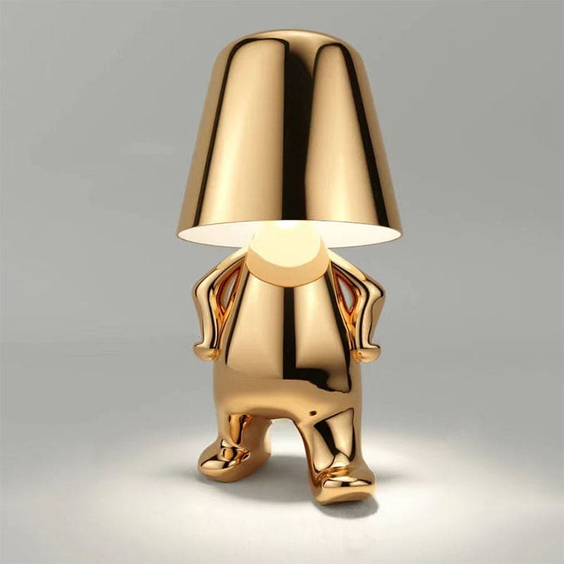 Goldene Designer-Tischlampe in menschlicher Form, modernes Interieur, stilvolle Beleuchtung, einzigartiges Wohnaccessoire, glänzendes Finish.