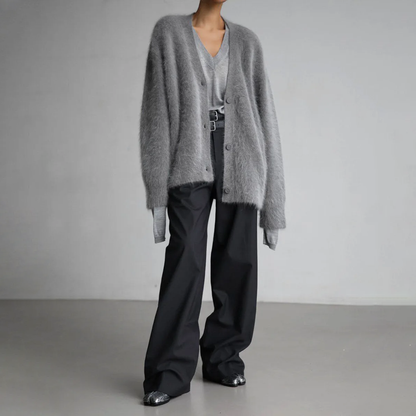 Grauer Oversize-Cardigan und schwarze weite Hose, modisches Outfit für Herbst/Winter. Eleganter, minimalistischer Stil, ideal für kühle Tage.